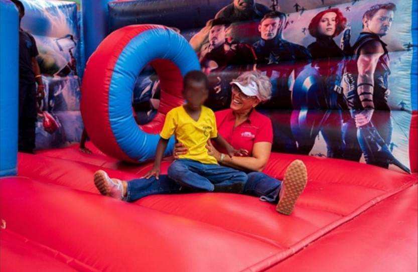 Kim Mair, Chief Executive Officer, JMMB Joan Duncan Foundation shares a joyful moment with a child from the Salvation Army School for the Blind at its Annual Children’s Day Celebration, where the JMMB Joan Duncan Foundation helped create a vibrant and inclusive space for visually impaired children to engage, connect and experience moments of joy and celebration.